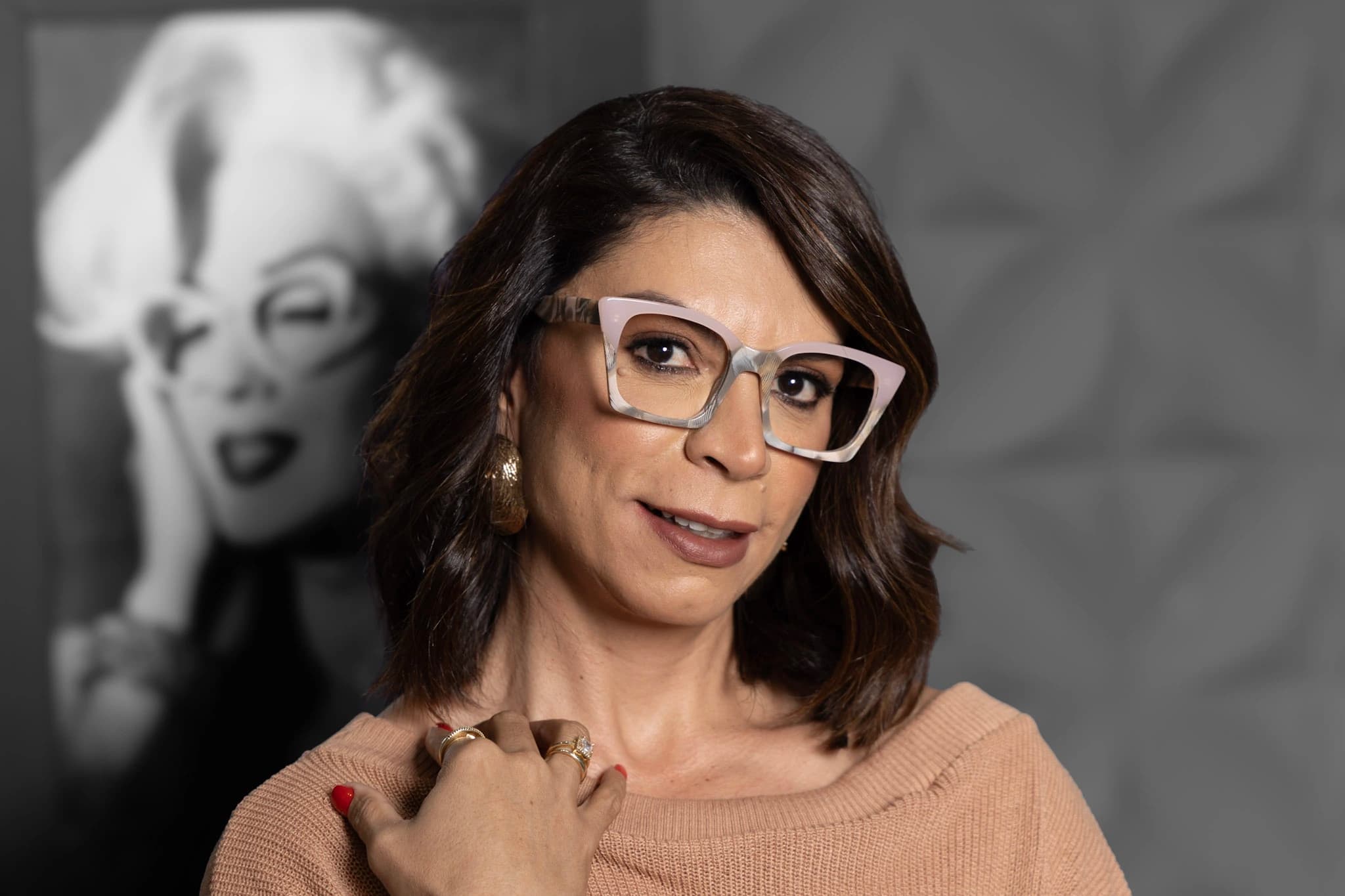 Modelo da Ótica CAP de óculos de grau com armação clara, diante de um retrato clássico em preto e branco.